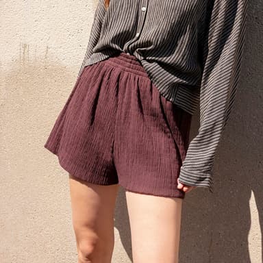 woman in dark chocolate brown shorts and black and white button-up shirt